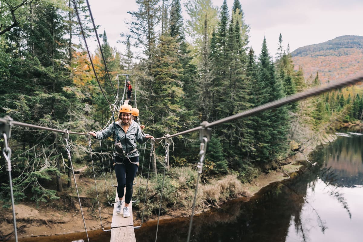 Woman on a suspended footbridge at parc national du Mont-Tremblant.