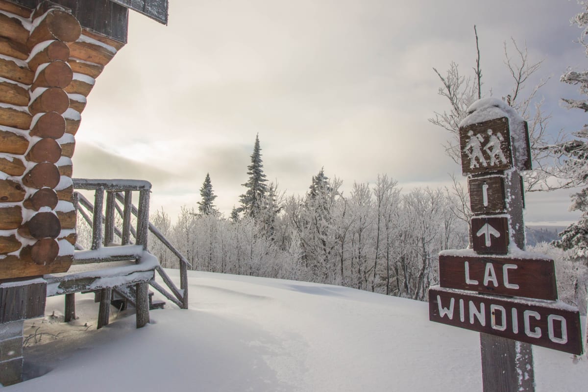 Signalisation vers le lac Windigo à côté d'un chalet en bois rond au parc régional Montagne du Diable.