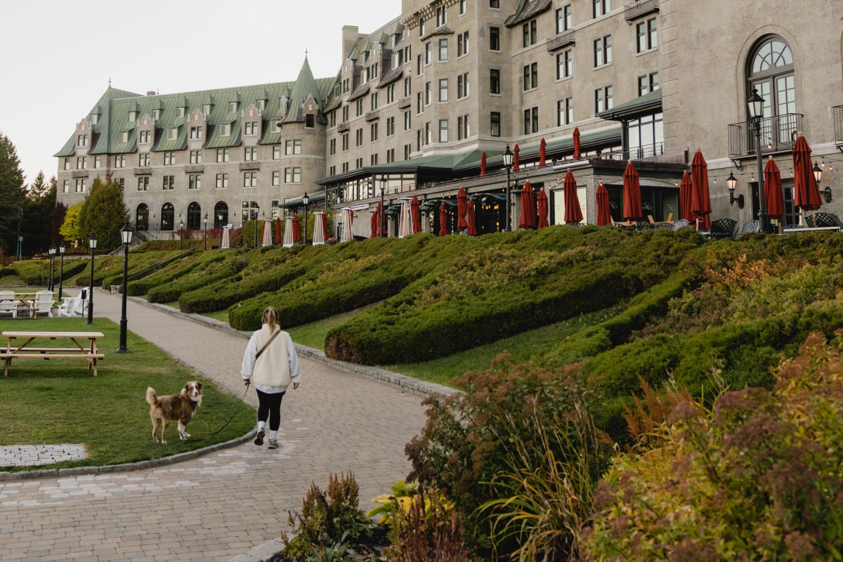 Woman with a dog in front of the Fairmont Manoir Richelieu