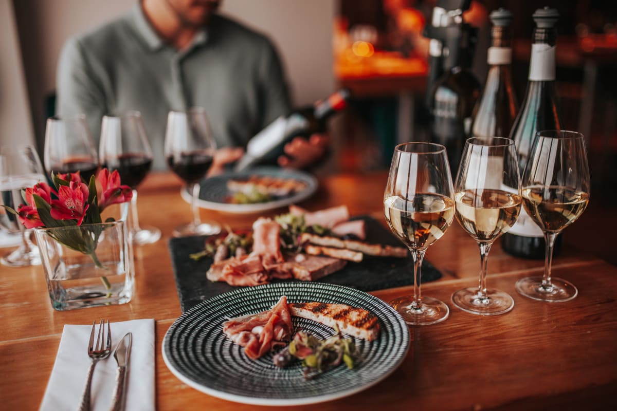 Tasting experience with multiple glasses of wine and a plate of food.