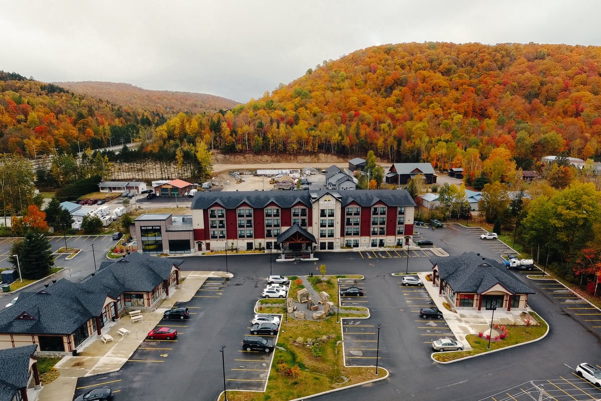 Front view of the Microtel Inn in Tremblant with a background of fall foliage.