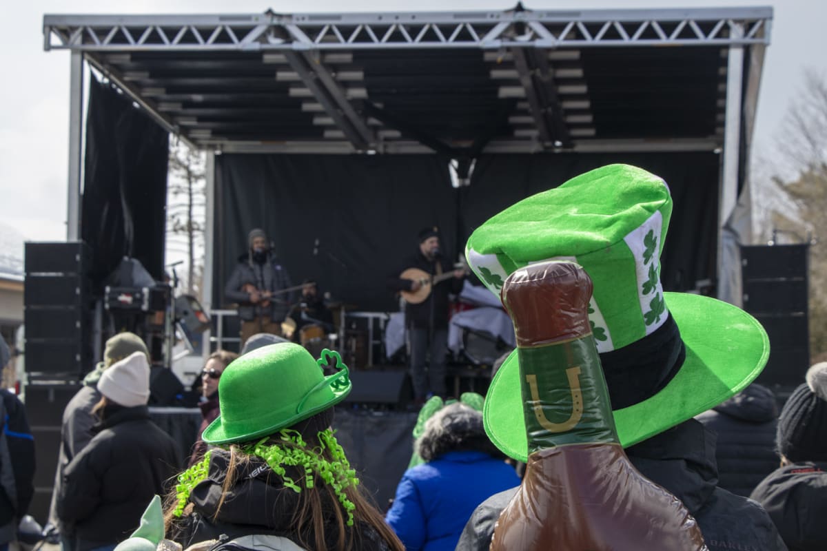 Stage and spectators wearing St Patrick's Day hats.