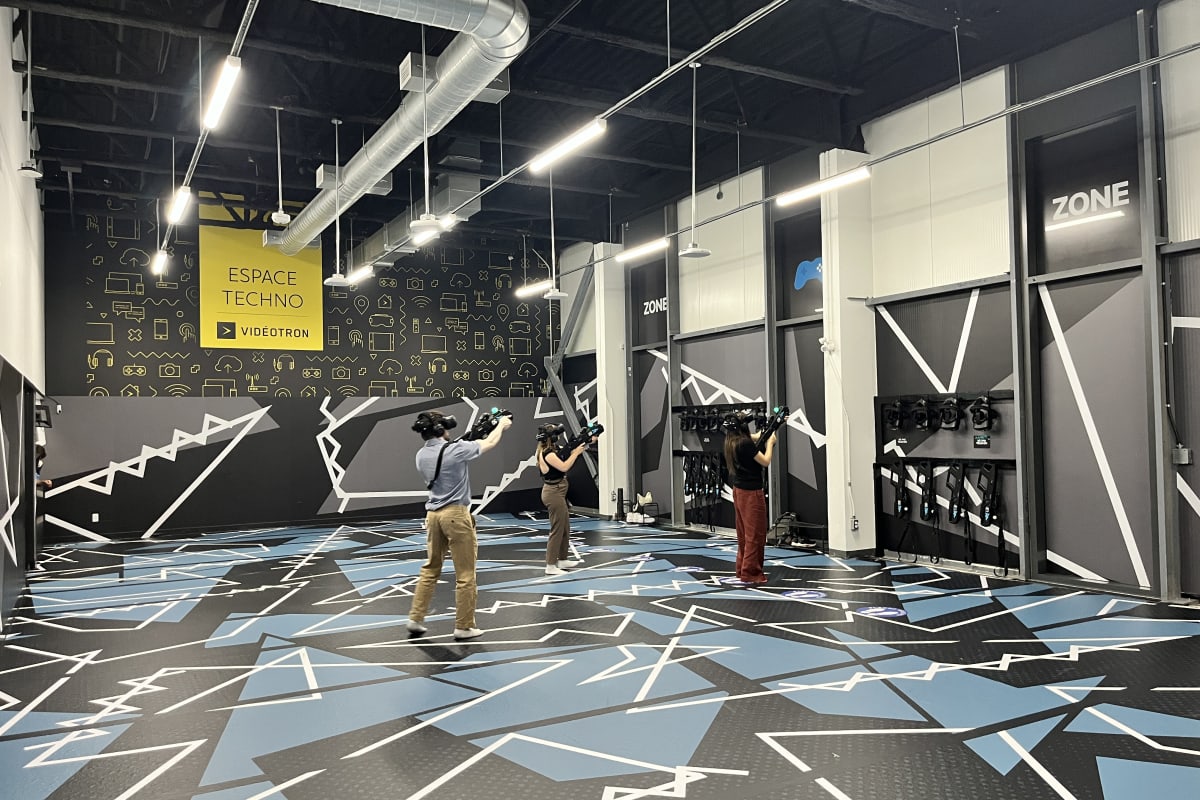 Trois personnes dans une arène de réalité virtuelle.
