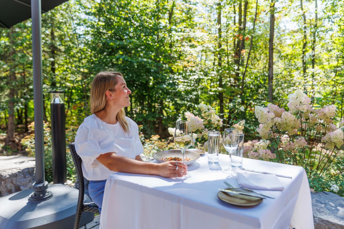 Femme assise à une table d'une terrasse