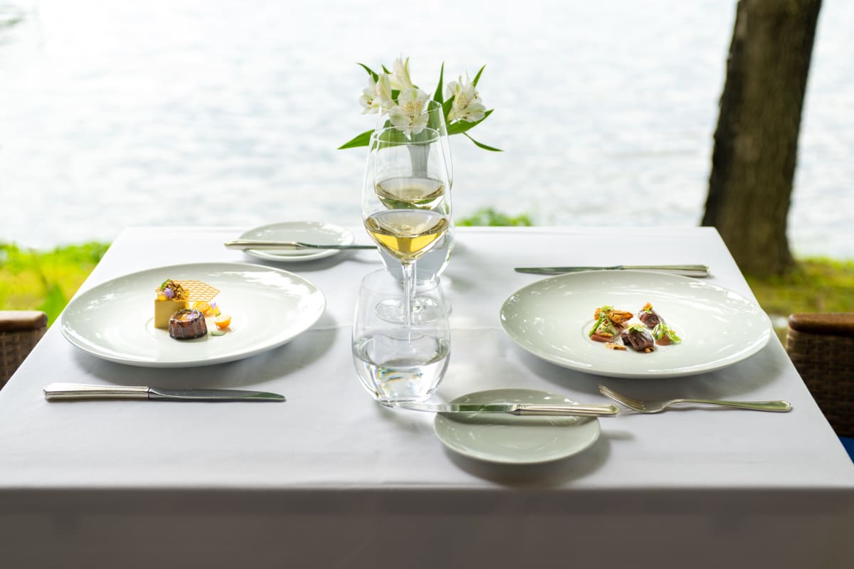 Table au bord de l'eau avec deux assiettes l'été au Ripplecove.