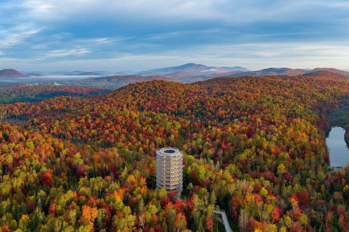 Vue aérienne de la tour panoramique du Sentier des cimes, entouré de montagnes colorées.