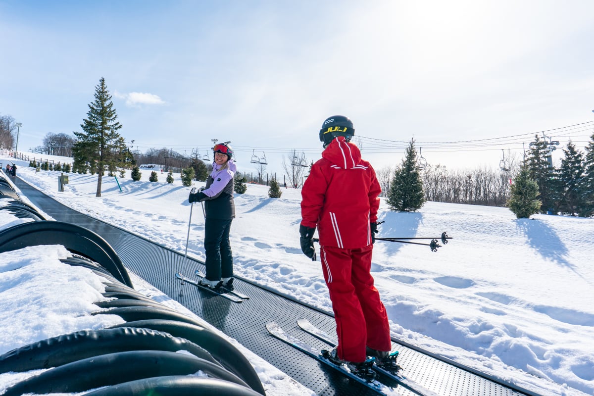 Young woman on the ski lift with her instructor.