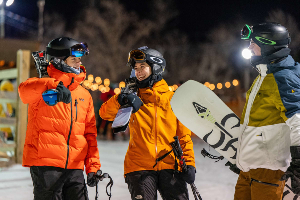 Group of three friends with their snowboards and skis.