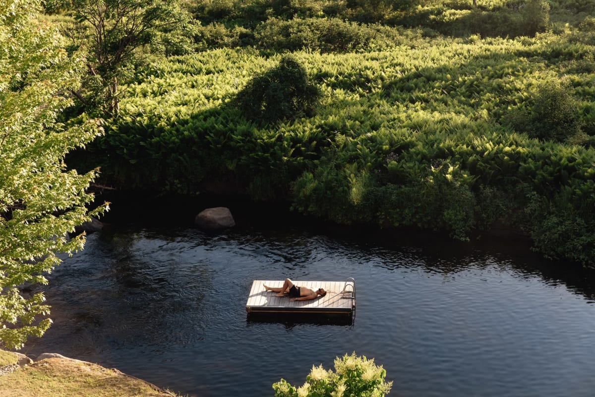 Homme étendu sur un quai dans un plan d'eau.