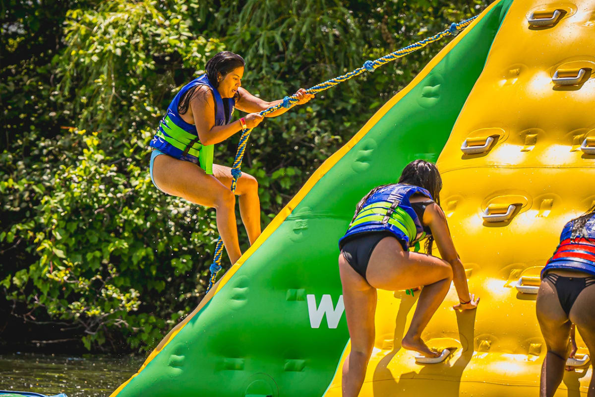 People climbing a spectacular floating inflatable structure at the Super Aqua Club
