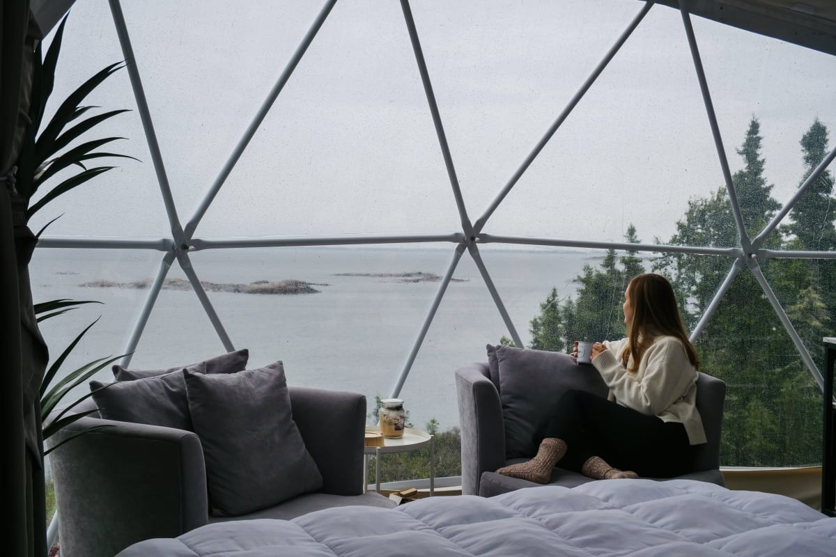 Woman in a unit shaped like a bubble at En Forêt in Côte-Nord.