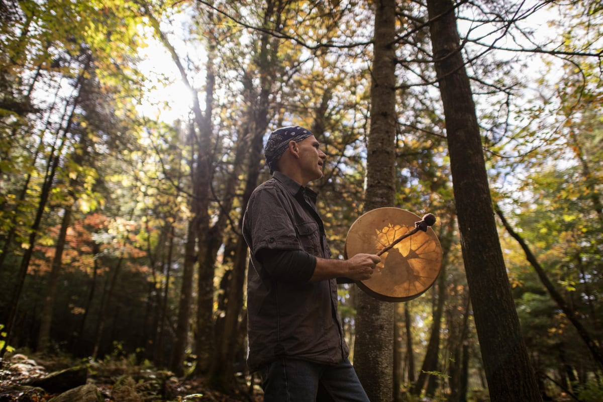 Drum player in a forest in Quebec.