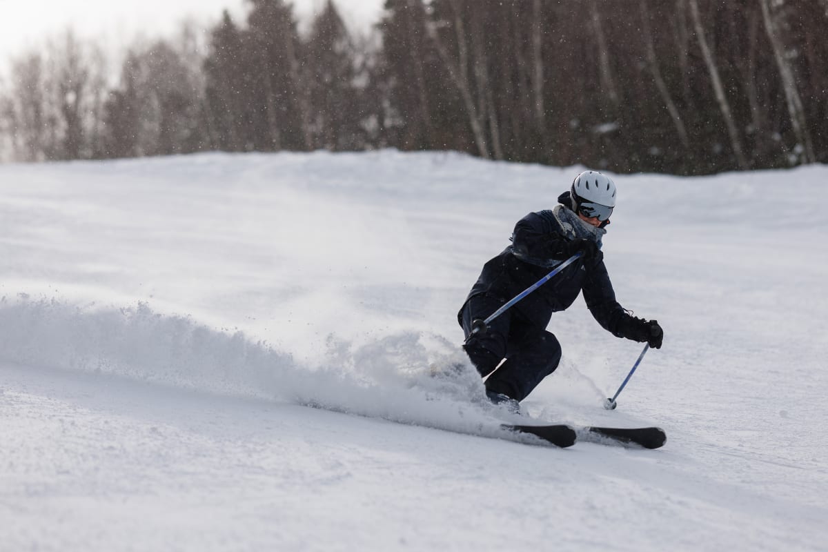 Person skiing downhill on an ski slope.