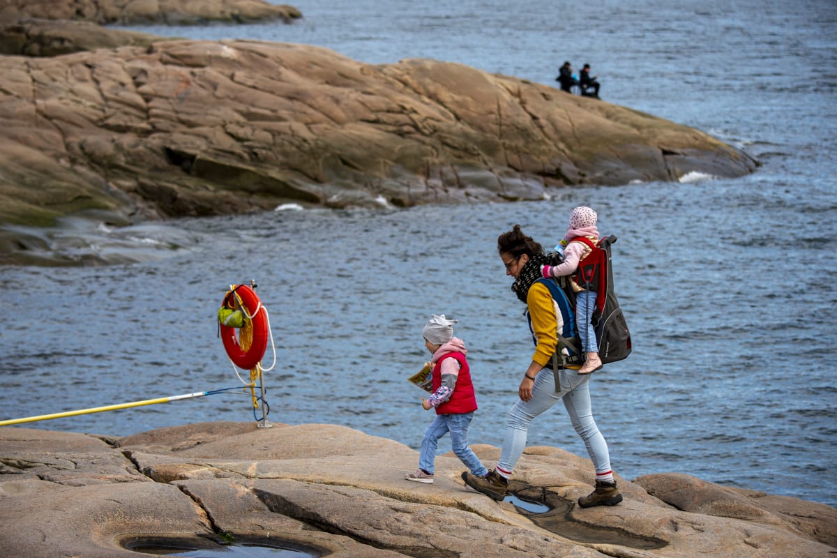 Mère et deux enfants en randonnée sur le bord de la mer.