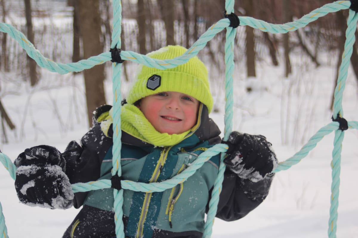 Kid in an outdoor playground in the winter.