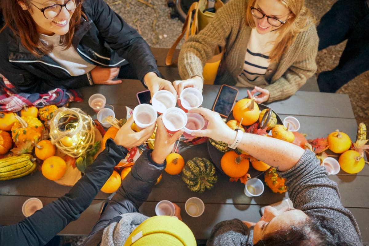 Group of women around a table decorated with pumpkins.
