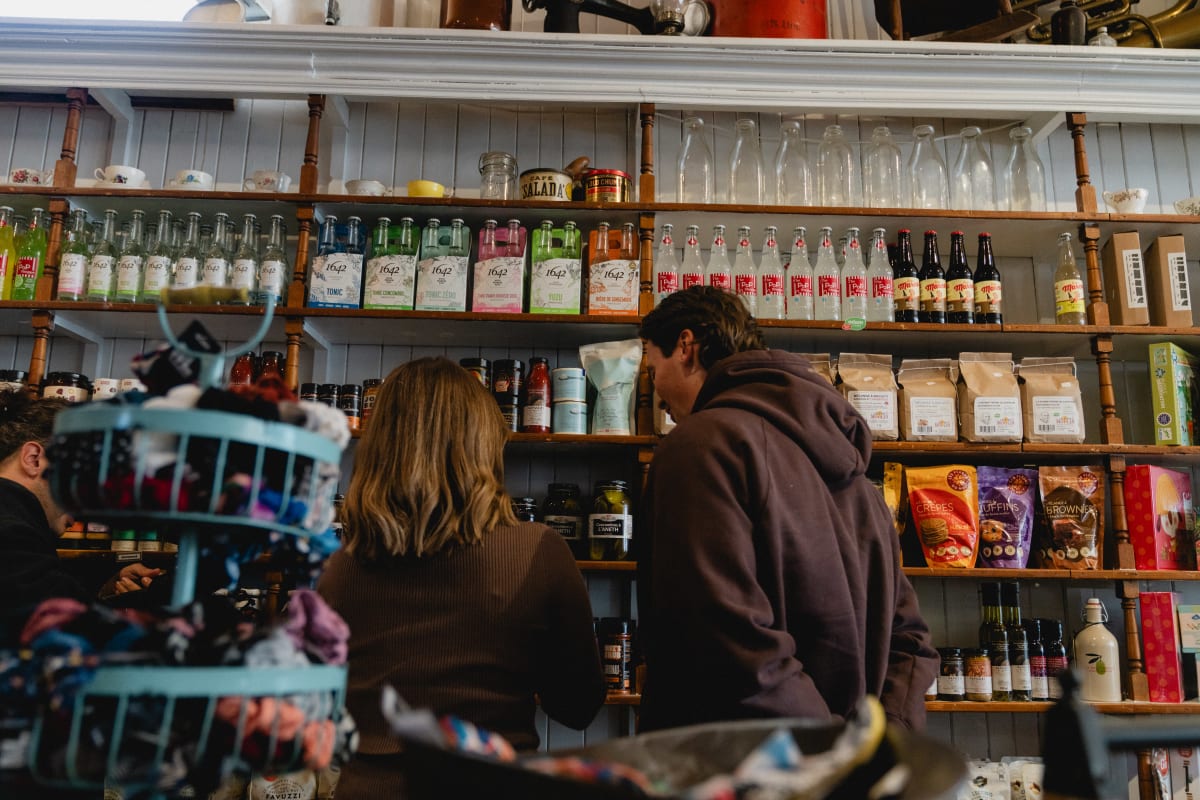 Couple au comptoir du café et bel étalage d'antan.