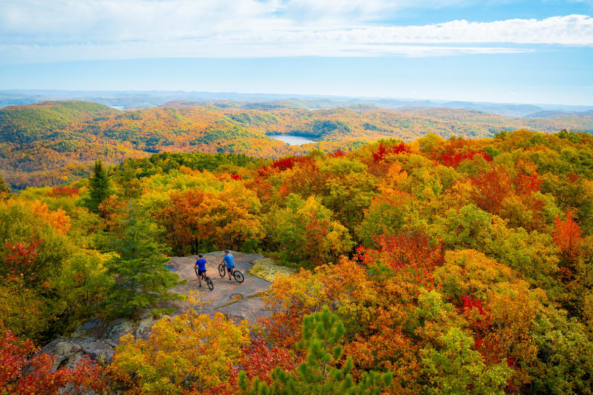Deux cyclistes en haut d'une montagne à l'automne.