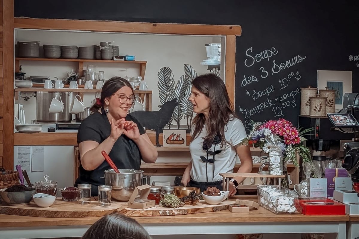 Two women standing behind a counter in a bakery.