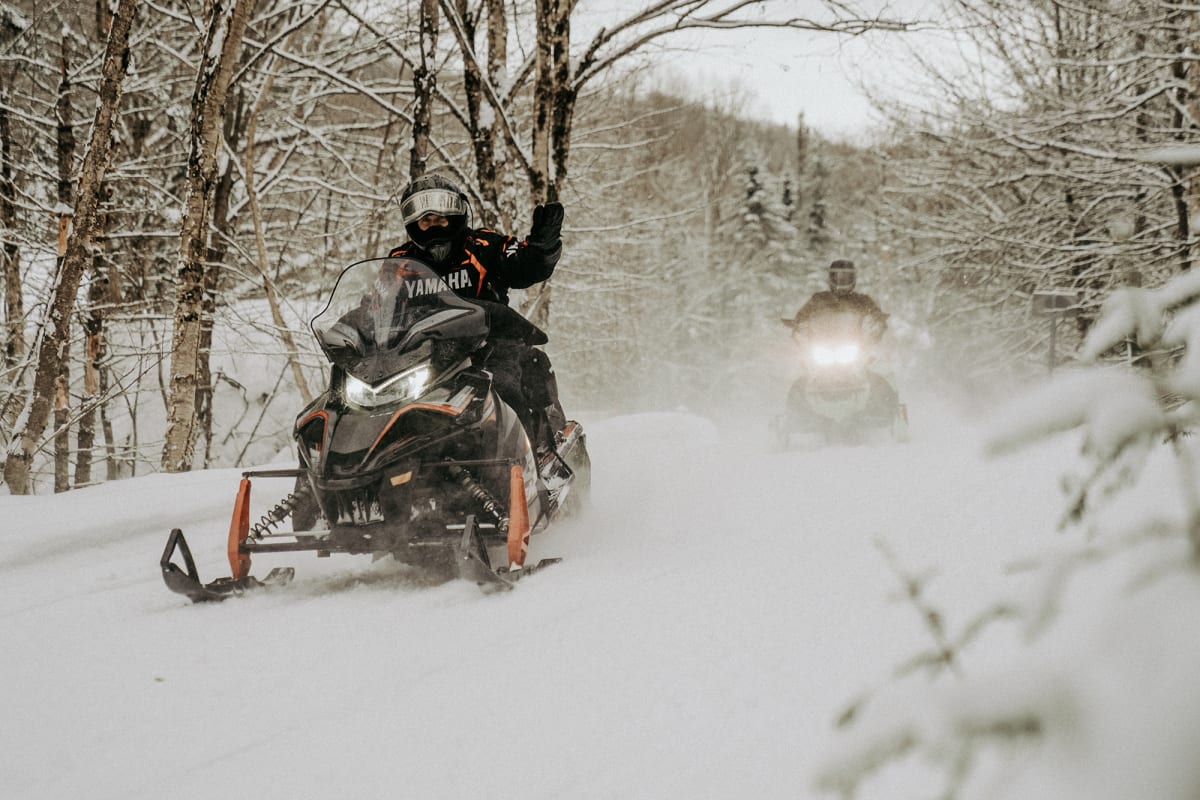 Two snowmobilers on a trail.