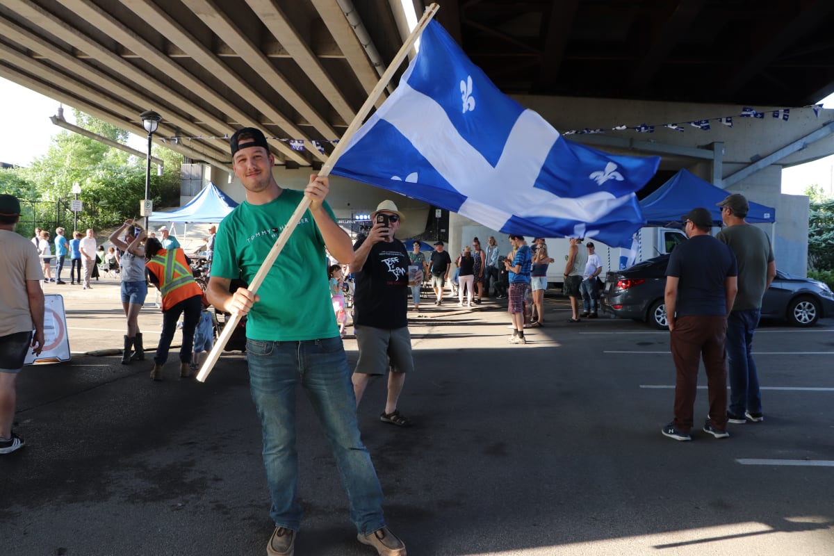 Homme brandissant le drapeau du Québec à la St-Jean-Baptiste - Sainte-Anne-de-Bellevue.