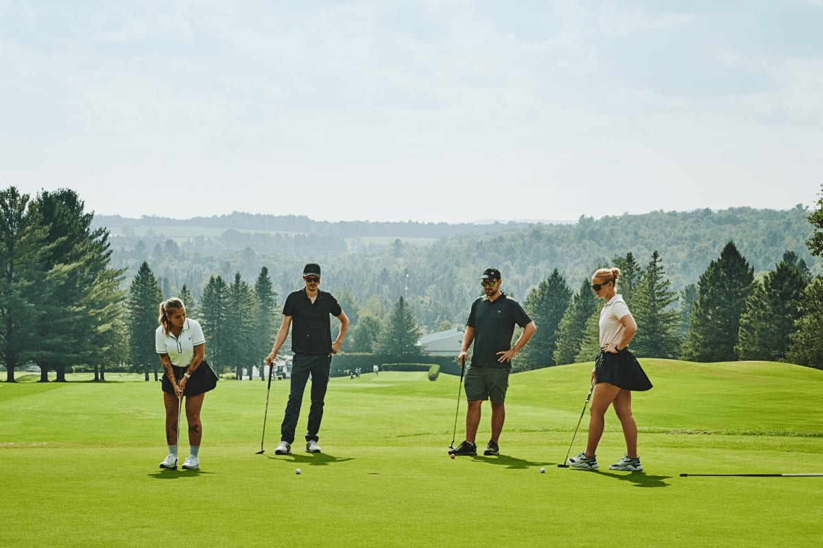 Quatre personnes sur un vert au Club de golf de Milby.