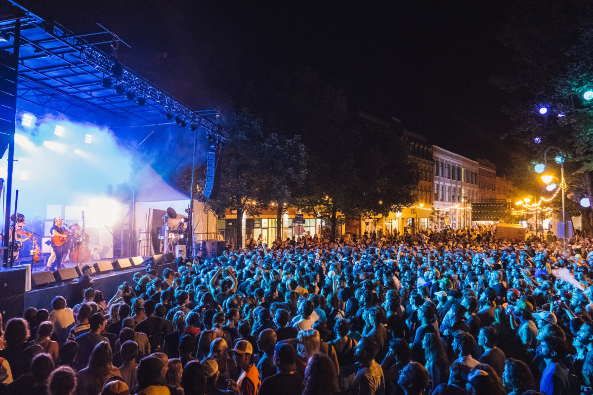 Foule en soirée devant une scène extérieure au Festival Sherblues.