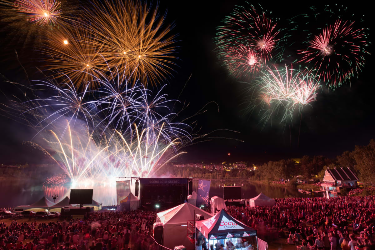 Feux d'artifice au-dessus d'une foule rassemblée lors de la Fête du Lac des Nations.