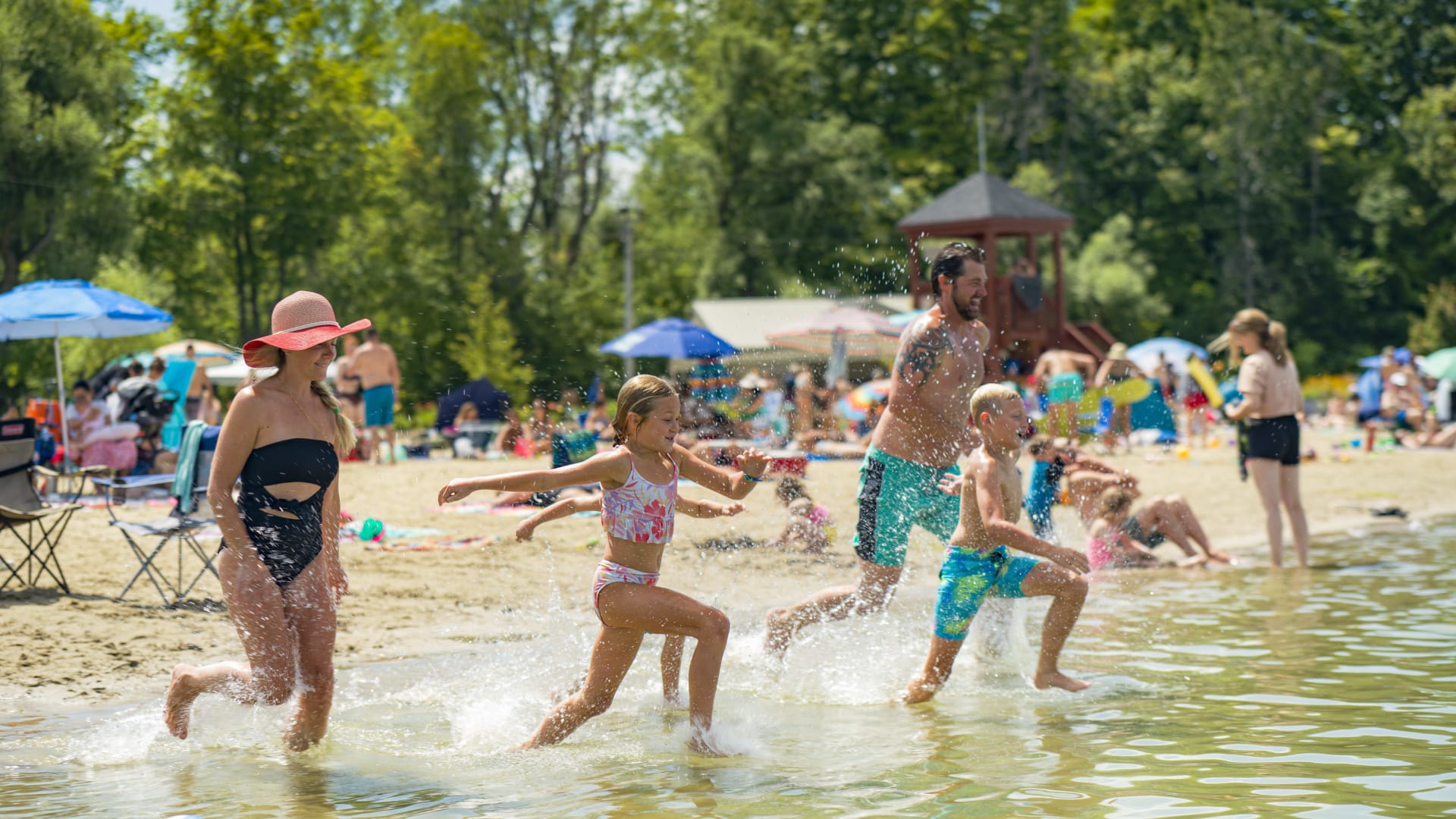 Famille courant dans l'eau à la plage.