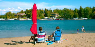 Centre de villégiature Dam-en-Terre - Deux personnes assises sur des chaises à la plage