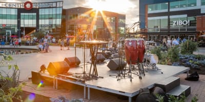 Une petite scène de concert en plein air, entouré du centre commercial Centropolis.