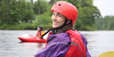 Expéditions Nouvelle Vague – a smiling woman in a kayak