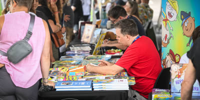 Festival de la BD de Prévost - Des bédéistes assis à des tables rencontrent des personnes