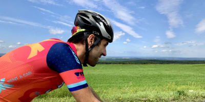 Hôtel Verso - A man is riding his bicycle on a road.