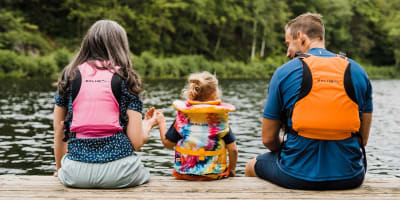 Kenauk Nature -  Two adults and a child on the edge of a quay, wearing life jackets