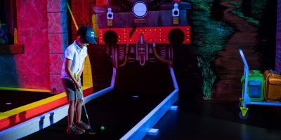 Children are playing a game of mini-golf at Laser Force Drummondville