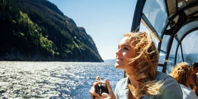 Les navettes maritimes du Fjord - Une femme sur un bateau tient une caméra.