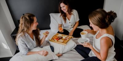 Three women having breakfast in bed
