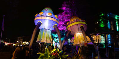 Lumifest Longueuil - Deux structures gonflables lumineuses en forme de vaisseaux spatiaux, entourées de spectateurs