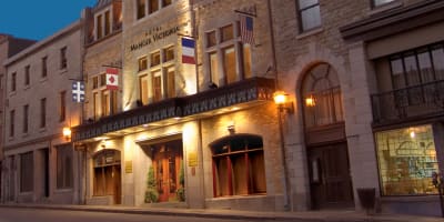 Façade de l'Hôtel Manoir Victoria en début de soirée.