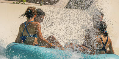 A family is having fun sliding down a waterslide at the Super Aqua Club.