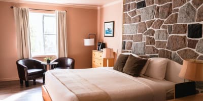 Pink room with a stone wall at Auberge La Rosepierre.