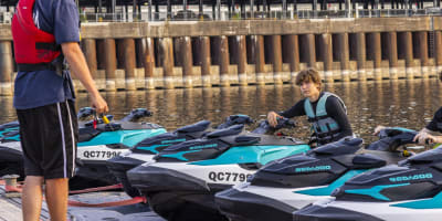 A young man prepares for a jet ski outing with an experienced guide.