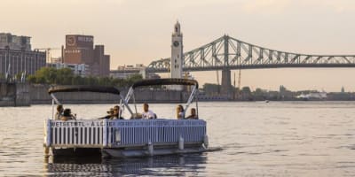 Friends are taking a cruise on the St. Lawrence River aboard an electric pontoon boat.