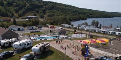 Pool and travel trailers at Camping Bas-St-Laurent.