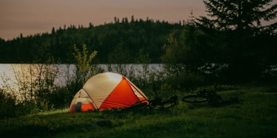 Une tente illuminée en soirée à la Réserve faunique des Laurentides.