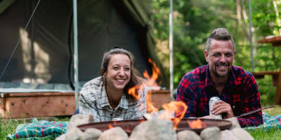 Couple devant un prêt-à-camper au Camping Sainte-Agathe-des-Monts au Parc régional Sainte-Agathe-des-Monts.