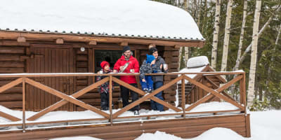 Une famille sur le balcon enneigé d'un chalet du parc national d’Aiguebelle.