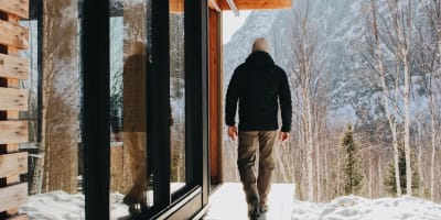 Un homme à l'extérieur d'un chalet du Parc national des Grands-Jardins en hiver.
