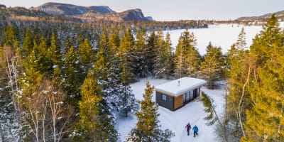 Deux personnes en raquette près d'un chalet du Parc national du Bic.